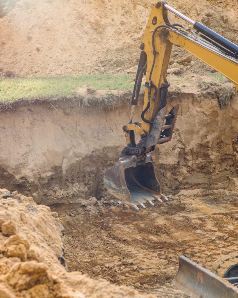 Industrial excavator in the construction of an underground foundation with family house